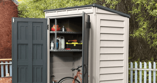 Vinyl shed with open doors showcasing organized storage for gardening tools and a bicycle in a backyard setting.