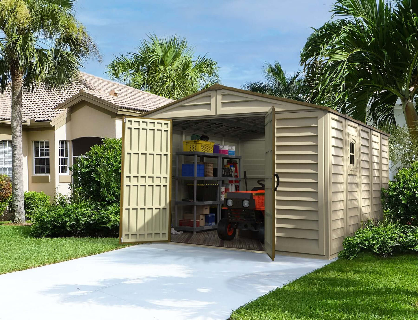 Duramax 10.5x13 Woodbridge Vinyl Shed with tools inside on concrete path, surrounded by green lawn and palm trees
