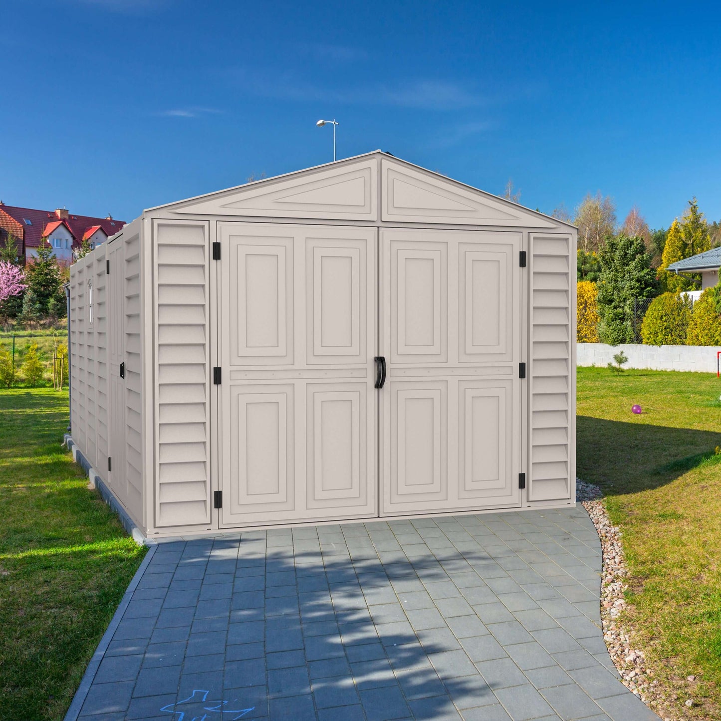 Duramax 10.5x15 vinyl garage with foundation in backyard, durable and rust-resistant for large storage.