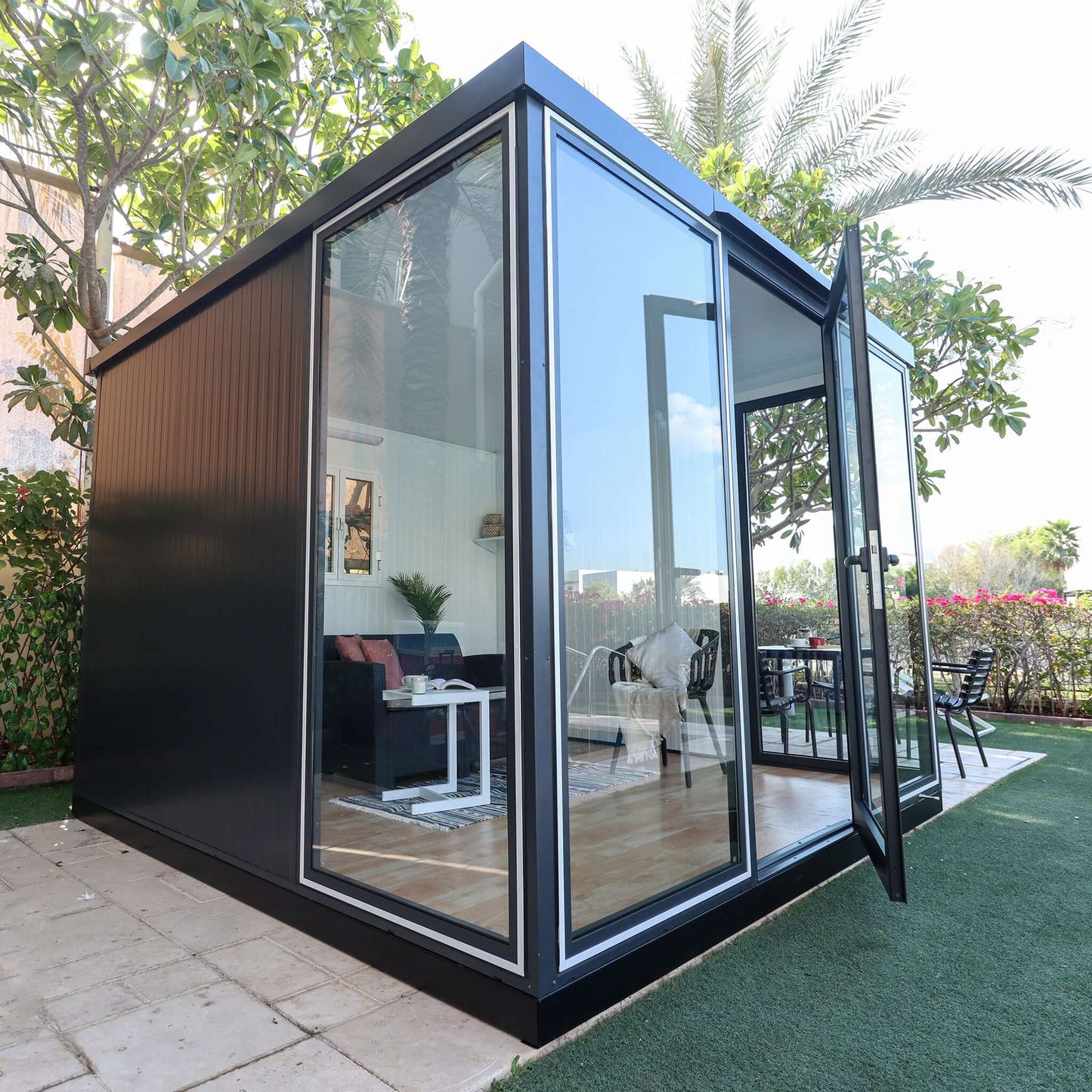 Duramax 10x10 glass garden room with clear glass panels, ideal for backyard use as a shed, office, or playroom.