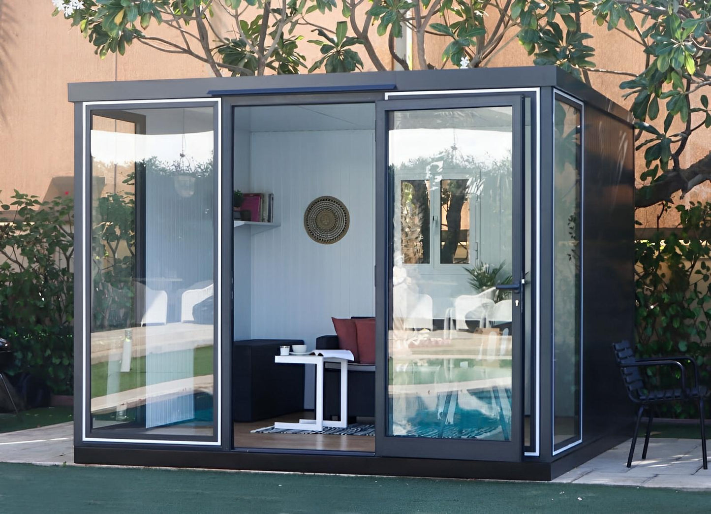 Duramax 10x10 Glass Garden Room used as a stylish outdoor space with clear glass panels, perfect for a garden shed or office.