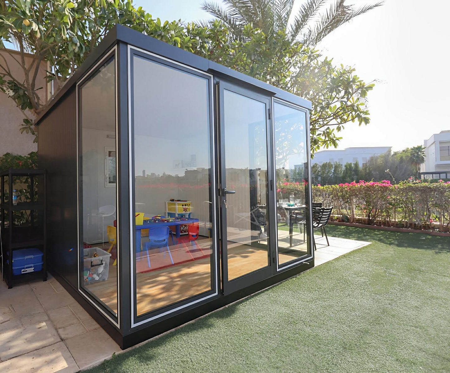 Duramax 10x10 Glass Garden Room in backyard, versatile for shed or office use.