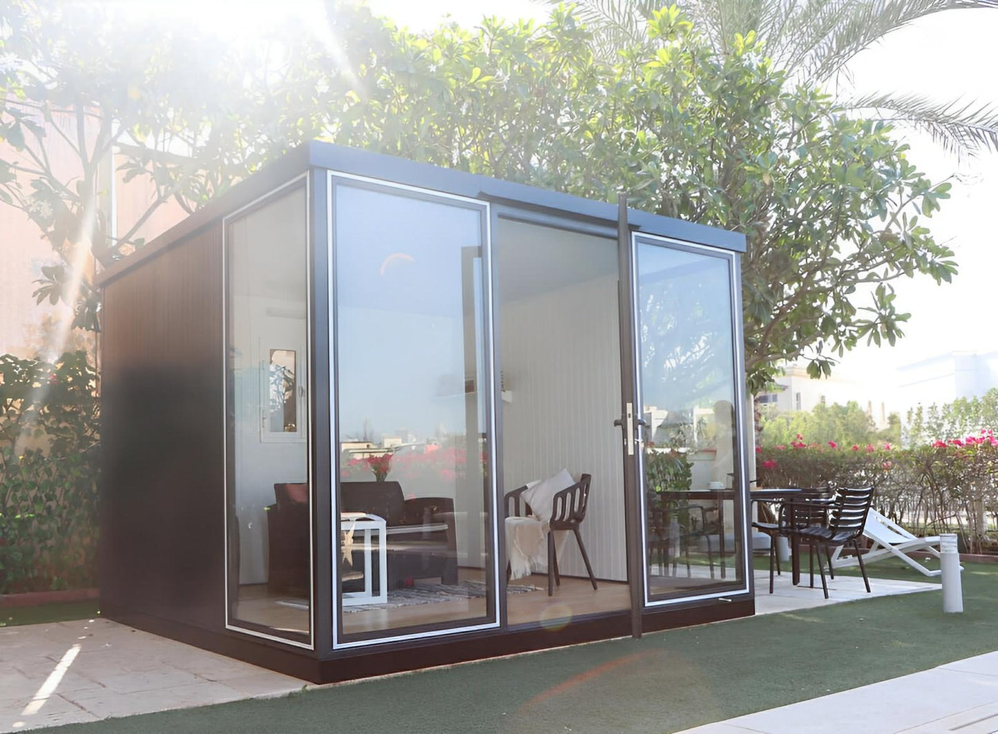 Duramax 10x10 glass garden room with steel and glass construction, ideal for backyard uses like office or guest room.