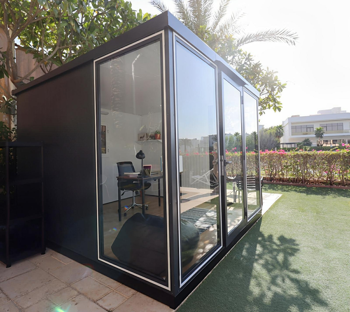 Duramax 10x10 Glass Garden Room 32001 in a backyard, showcasing a stylish and functional space with clear glass panels and sturdy steel walls.