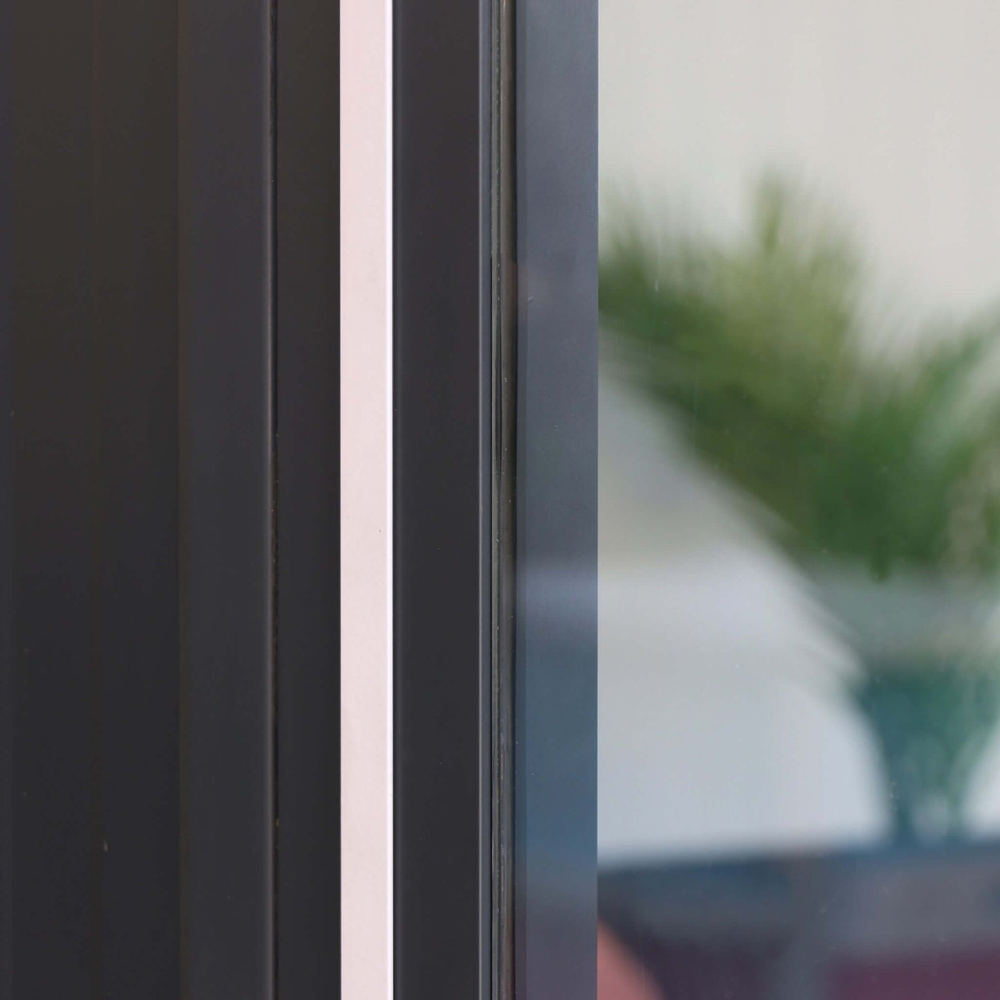 Close-up of Duramax garden room showing glass panel and steel frame, perfect for outdoor spaces as a shed, office, or playroom.