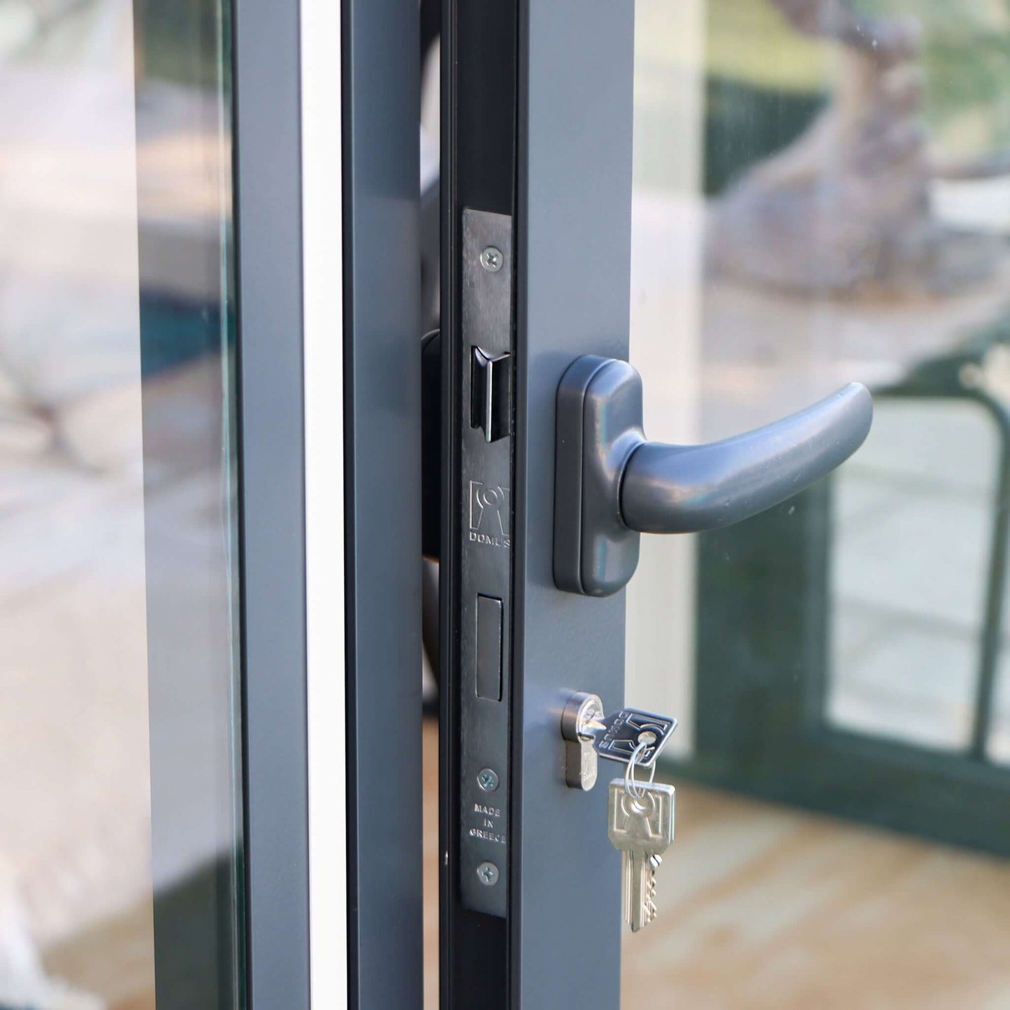 Close-up of a durable Duramax glass door handle and lock system on a garden room, highlighting security and design.