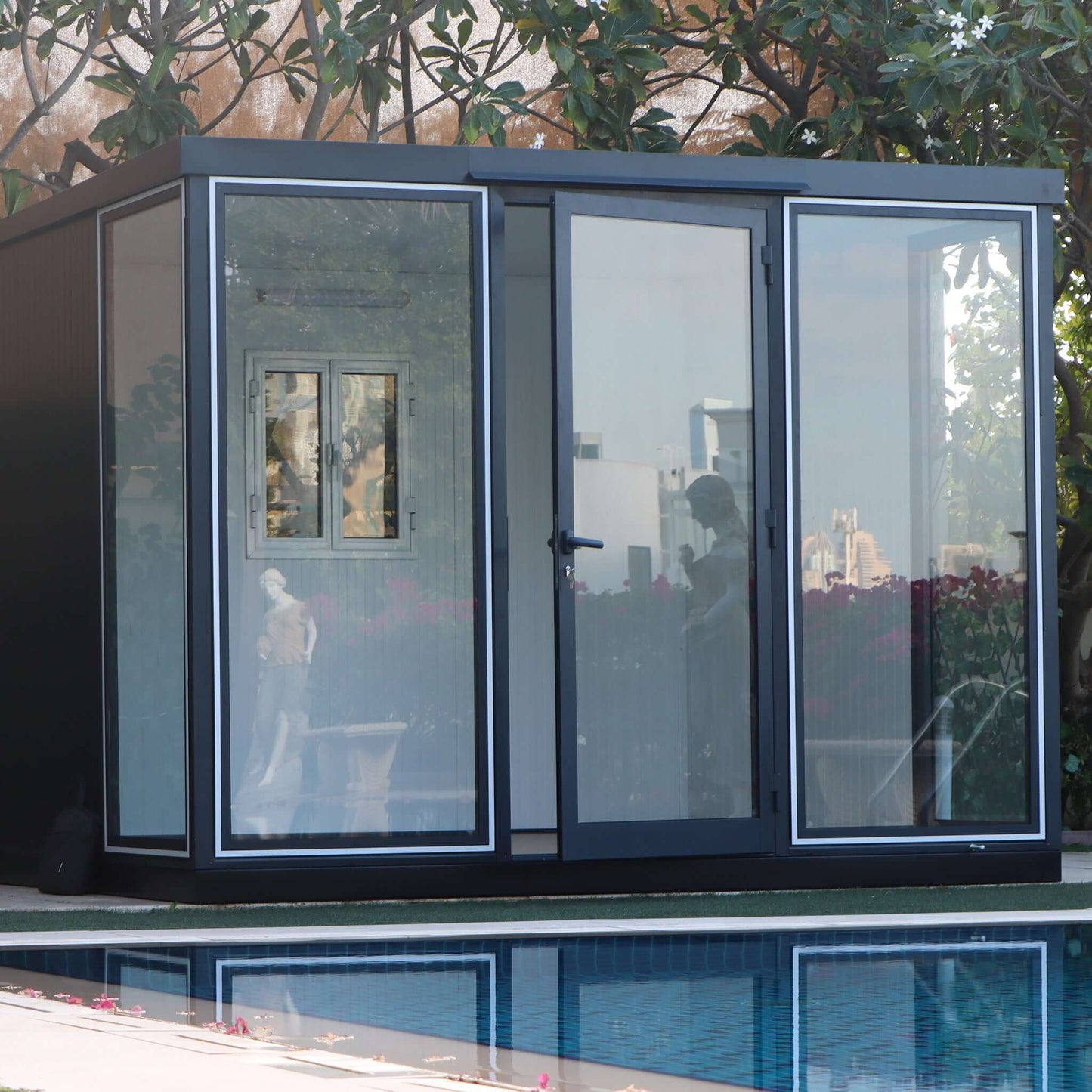 Duramax 10x10 glass garden room by the poolside, ideal for versatile outdoor use.