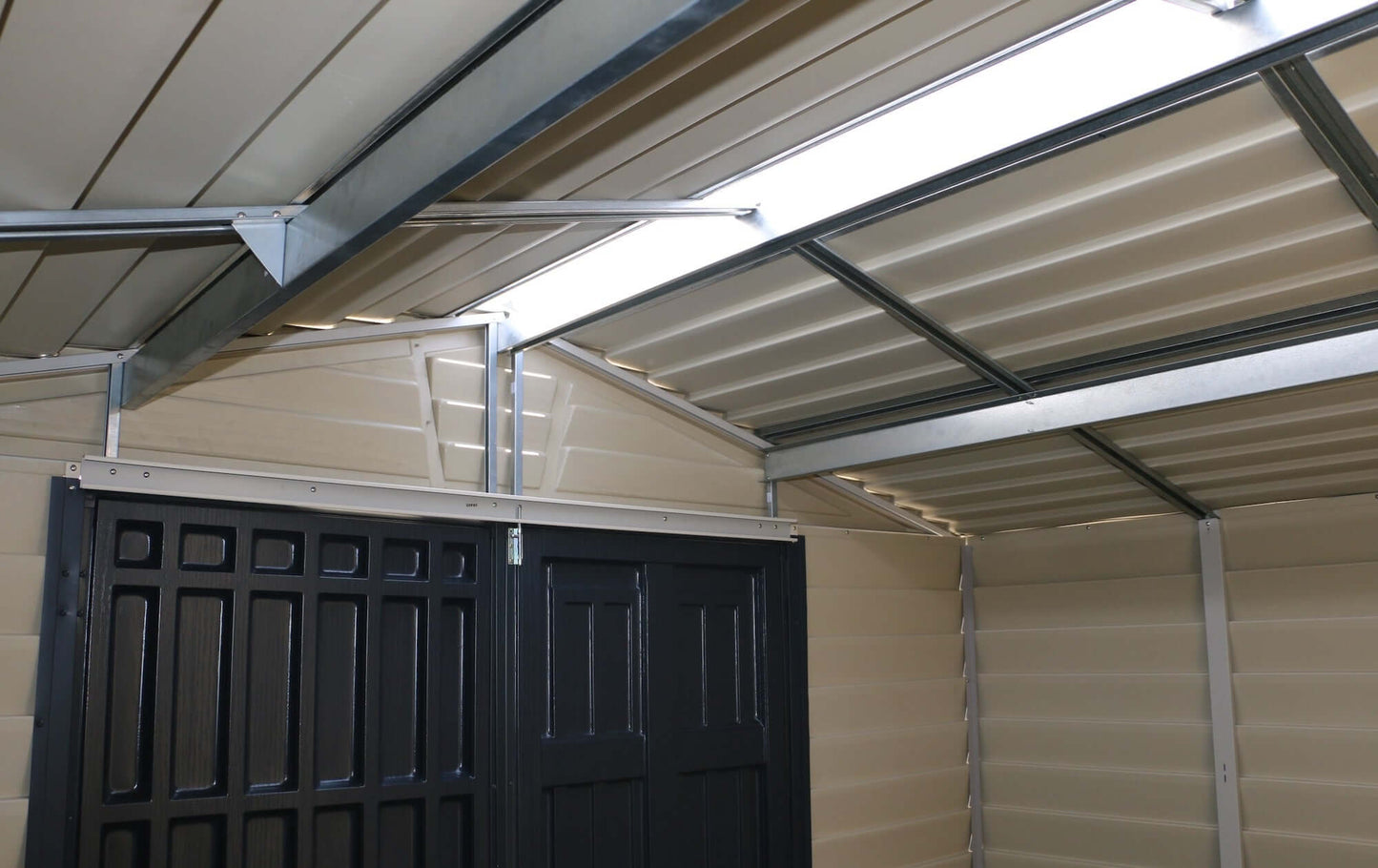 Interior view of Duramax 10x8 StoreMax PLUS Vinyl Shed with skylight, showcasing sturdy vinyl construction and ample storage space.