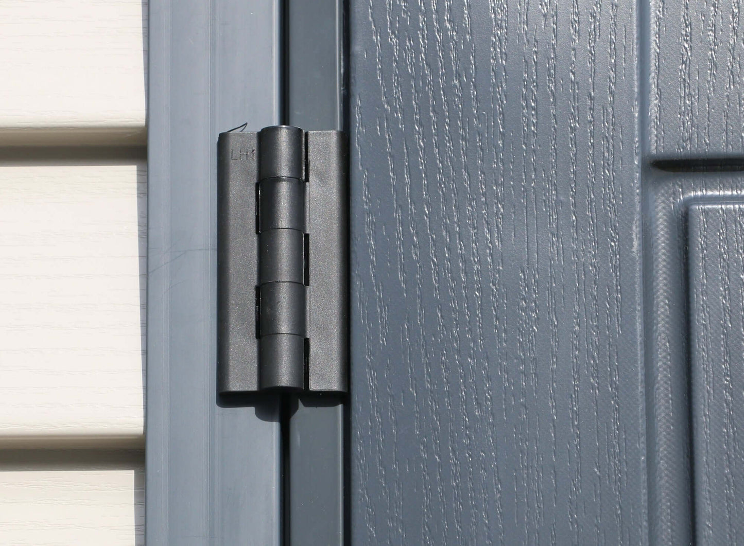 Close-up of Duramax shed door hinge showcasing durable vinyl construction.