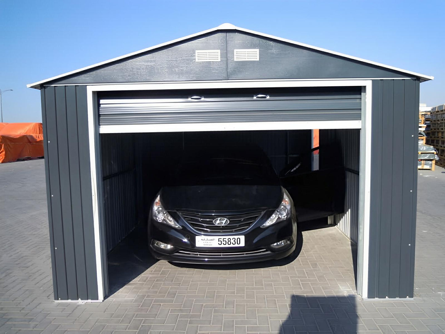 Duramax Imperial Metal Garage 12x20 in light gray with a car parked inside, showcasing sturdy steel construction and spacious design.