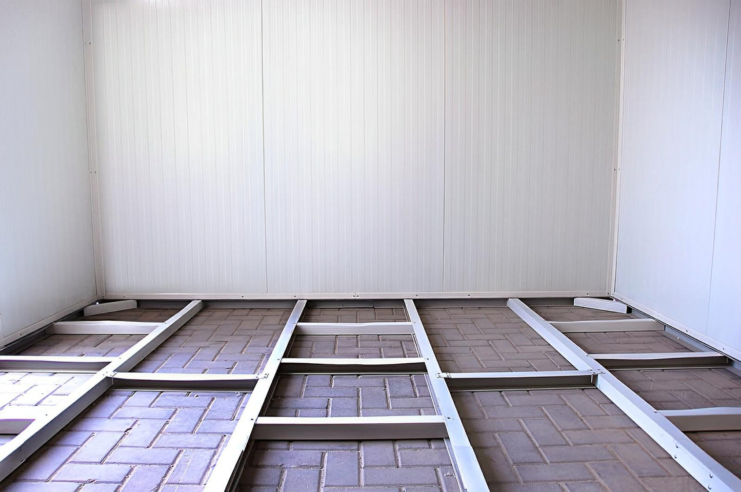 Interior view of a Duramax insulated building with exposed flooring grid, showcasing prefabricated design for easy installation.