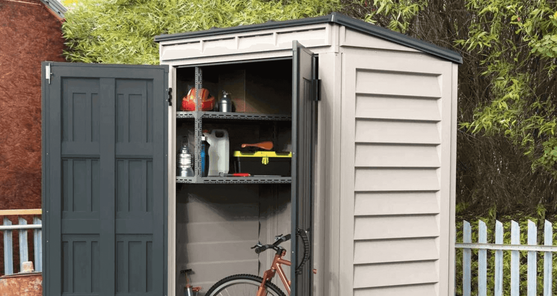 Vinyl shed with open doors showcasing organized storage for gardening tools and a bicycle in a backyard setting.