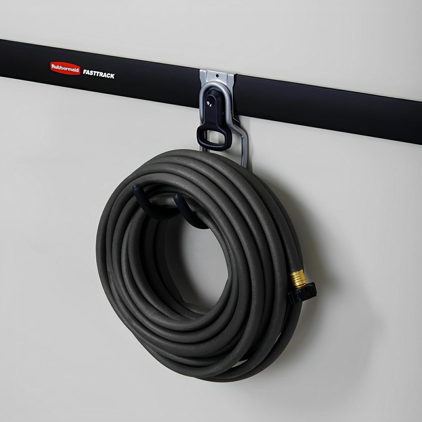 Rubbermaid FastTrack wall utility hook holding a coiled hose on a shed wall, showcasing durable and secure storage solution.