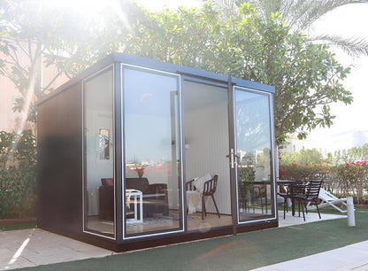 Duramax 10x10 glass garden room with steel and glass construction, ideal for backyard uses like office or guest room.