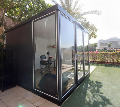 Duramax 10x10 Glass Garden Room 32001 in a backyard, showcasing a stylish and functional space with clear glass panels and sturdy steel walls.