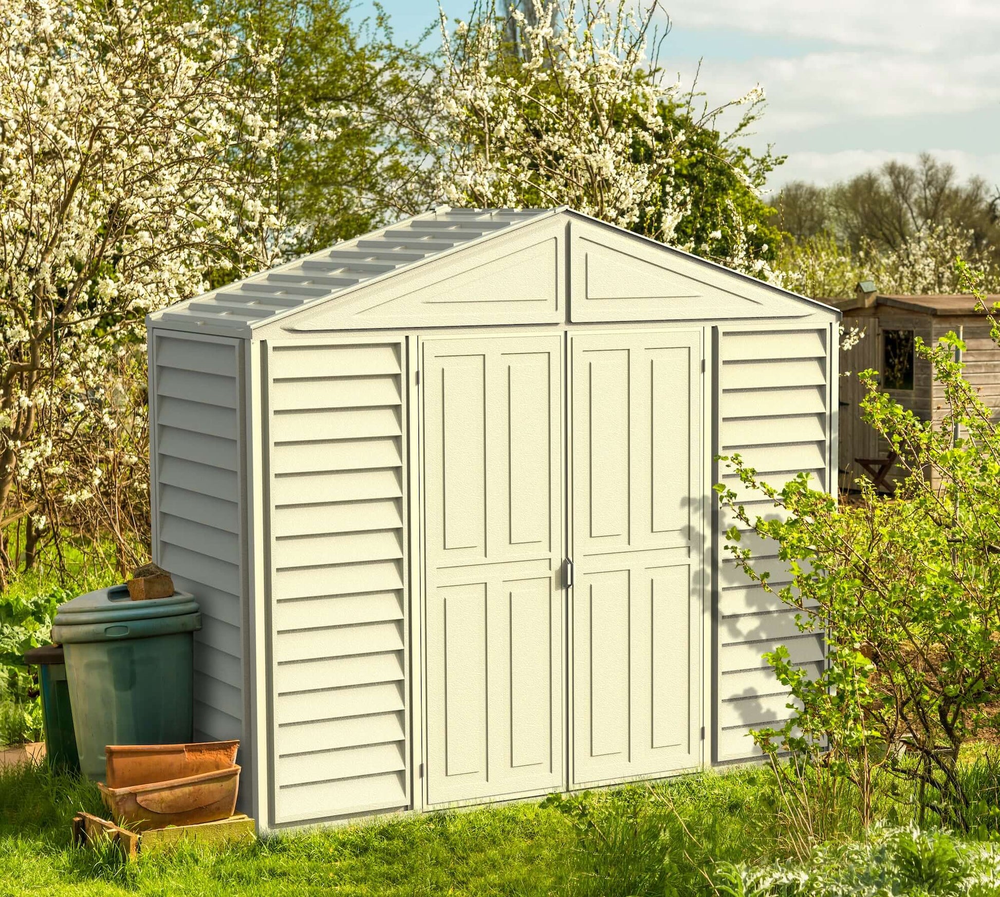 Duramax 10x3 SidePro Vinyl Shed with lean-to design in garden setting, perfect for extra storage. Duramax shed for versatile use.