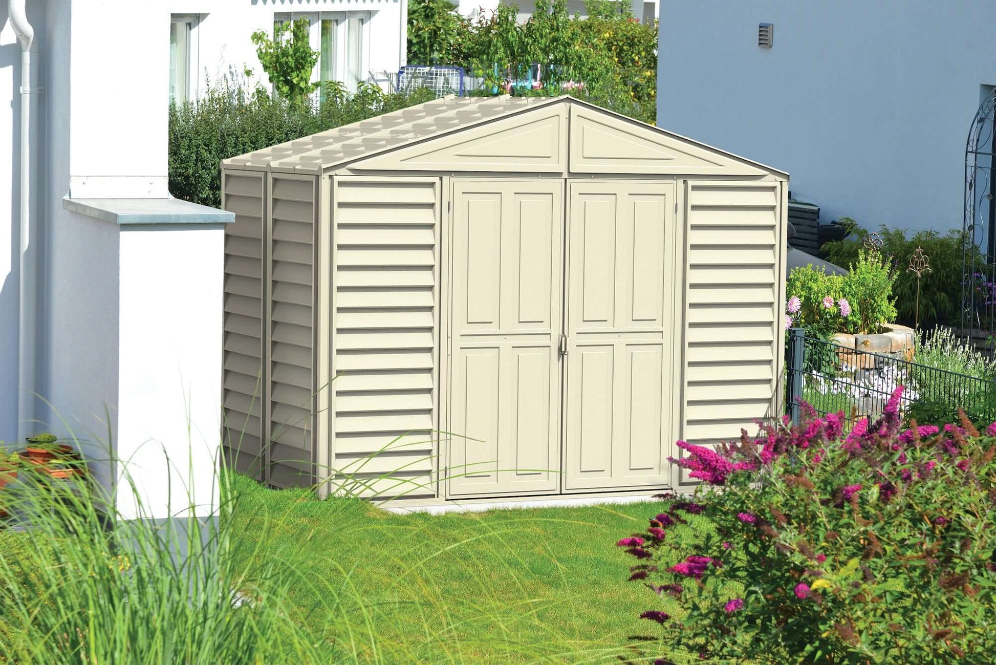Duramax 10x5 WoodBridge Vinyl Shed with Foundation in garden setting, ideal for tool storage. Keywords: Duramax shed, Duramax Sheds.