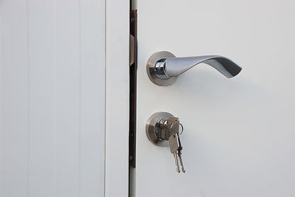 Close-up of a modern door handle and lock with keys in an insulated building.