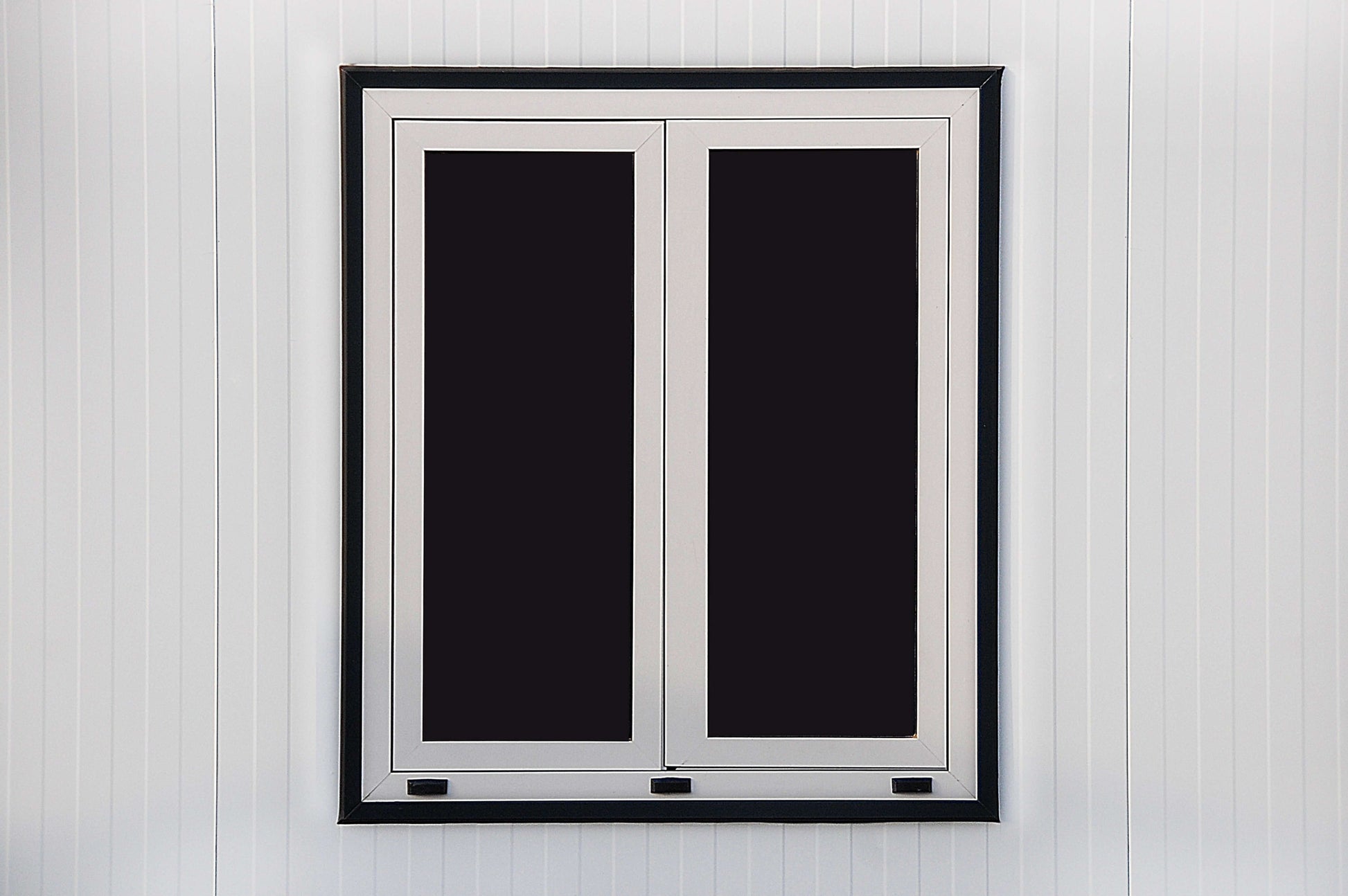White frame double window on a modern insulated building exterior wall