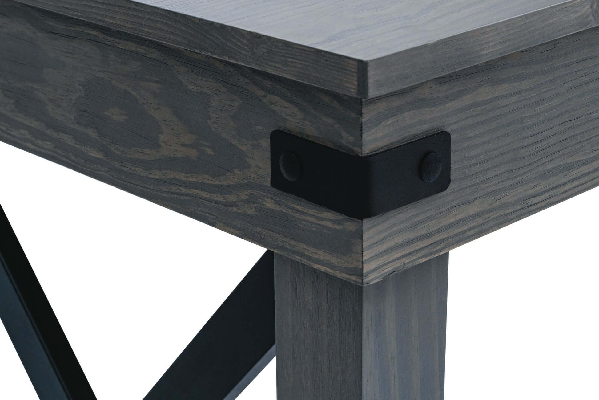 Close-up of Duramax Felix wood desk corner with black aluminum cross bar and solid wood legs.
