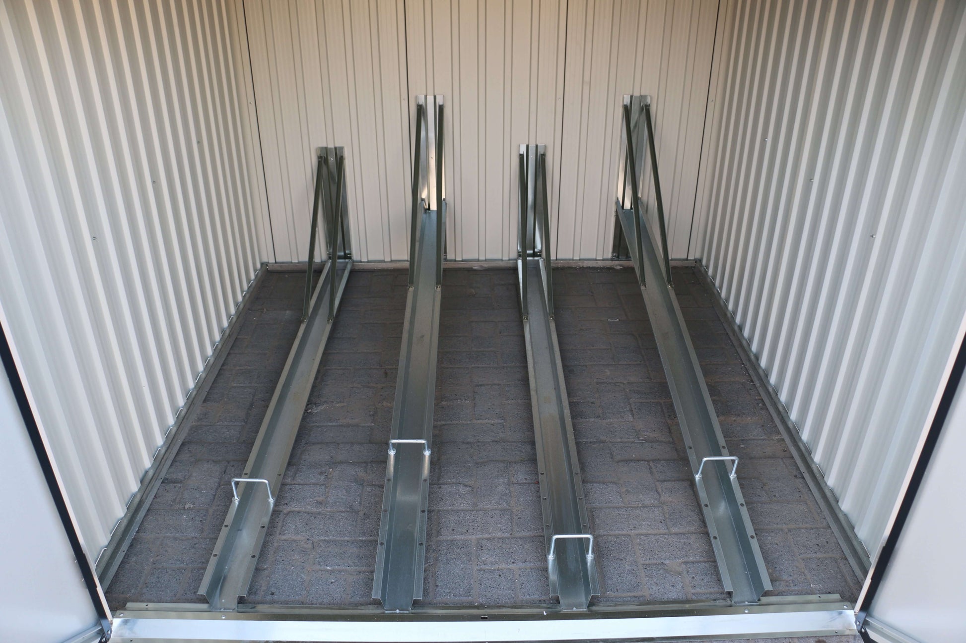Interior view of a Duramax 6x6 Bike Shed 73051 showing metal tracks for bike storage, made of weatherproof galvanized steel panels.