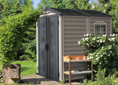 Duramax StoreMate PLUS 6x6 vinyl shed with floor, offering style, security, and fire-retardant vinyl construction against a garden backdrop.