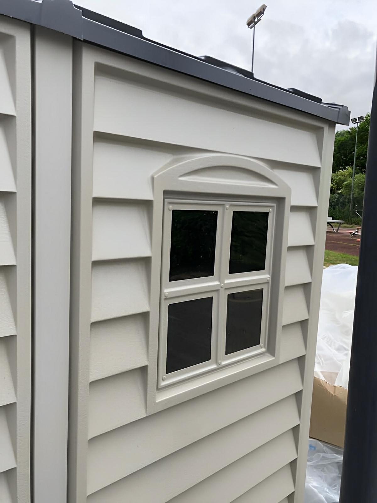 Side view of a Duramax StoreMate PLUS vinyl shed showing window detail, illustrating premium fire-retardant construction and design.