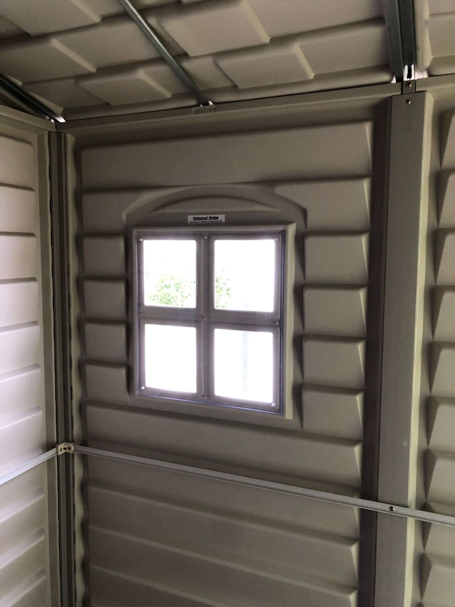 Interior view of Duramax 6x6 StoreMate PLUS shed showing vinyl panels and window design.