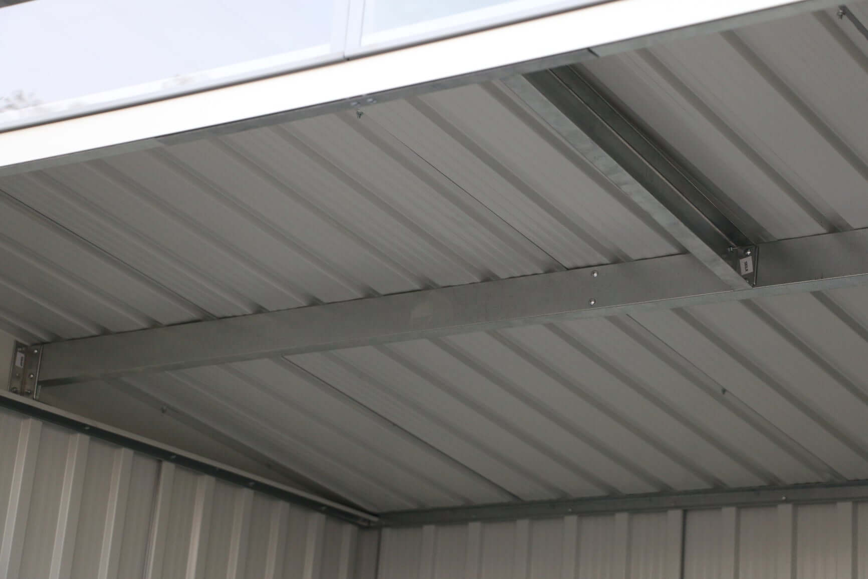 Interior view of Duramax 8x6 Metal Shed with pent roof and skylight, showcasing structural design. Keywords: duramax sheds, duramax shed.