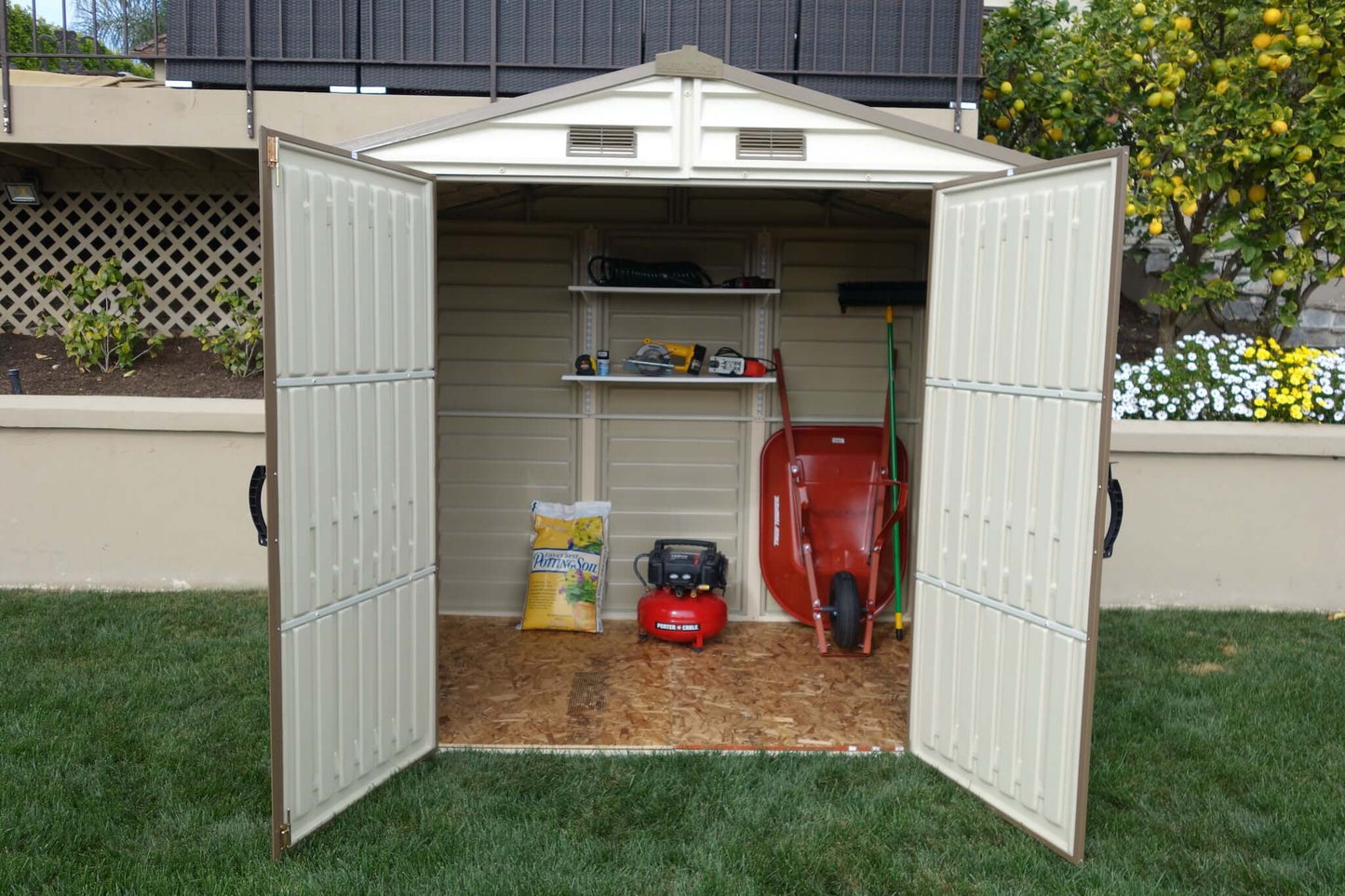 Duramax 8x6 StoreAll Vinyl Shed with foundation, garden equipment inside, open doors, ideal for outdoor storage solution
