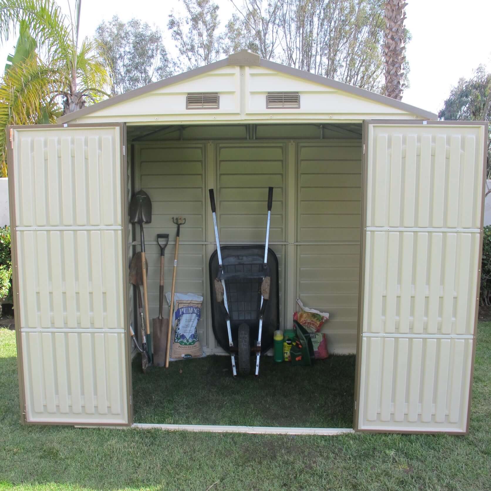 Open Duramax 8x6 StoreAll Vinyl Shed with tools and equipment inside, ideal for backyard storage. Featuring Duramax Sheds.